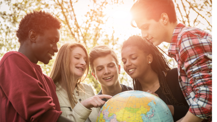 Fünf junge Leute schauen auf einen Globus
